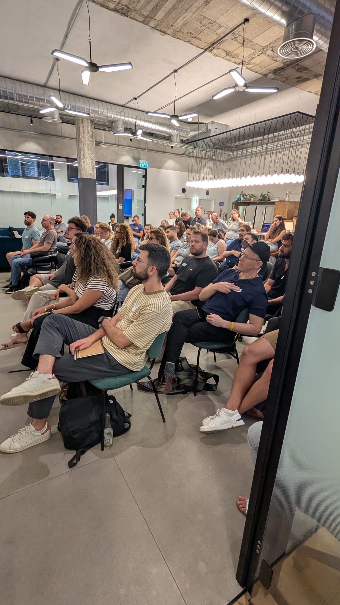 Rows of attendees watching a talk in the Sola Security office