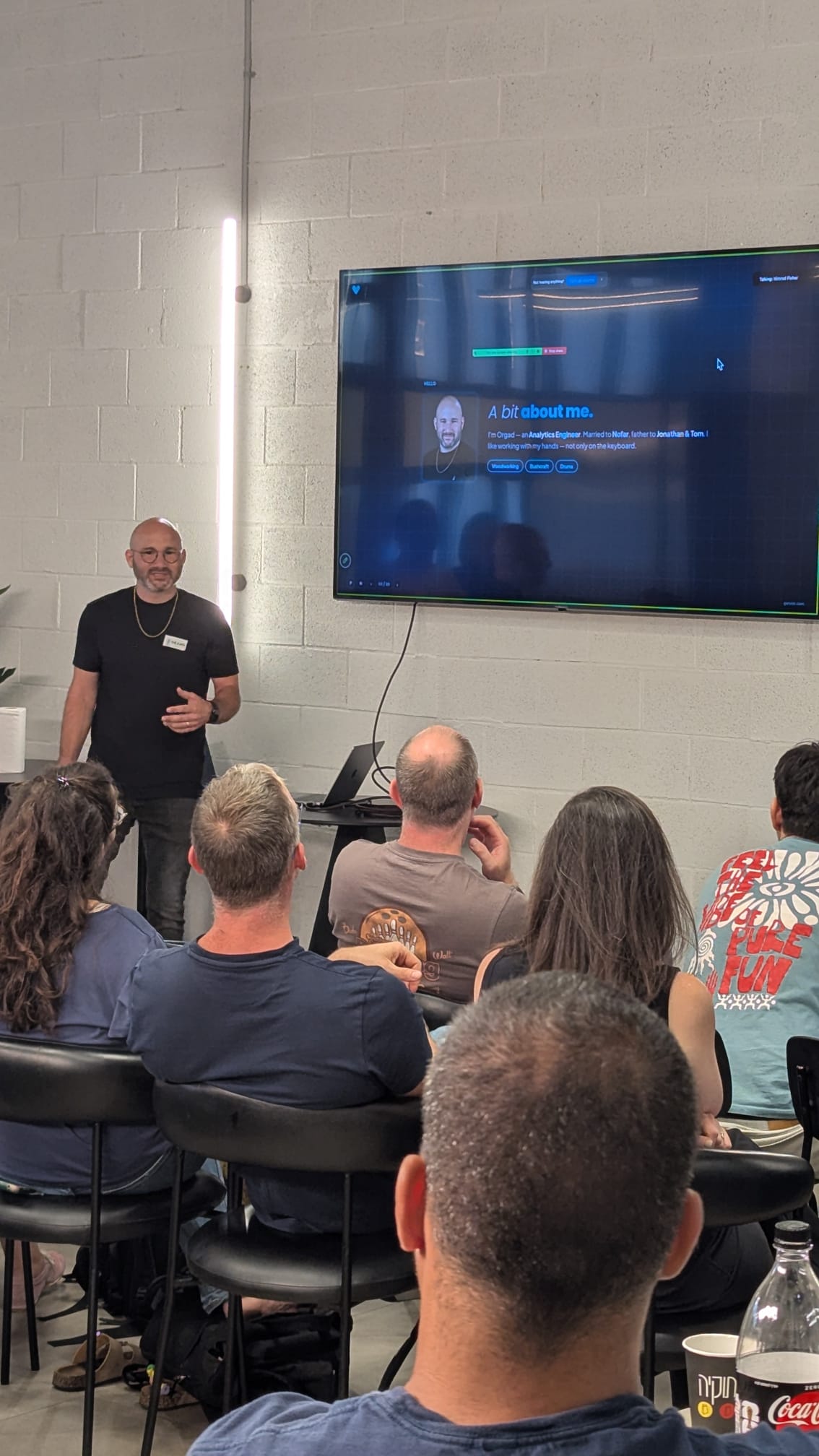 Orgad Salomon of Vim presenting to a seated audience, his intro slide on the screen behind him